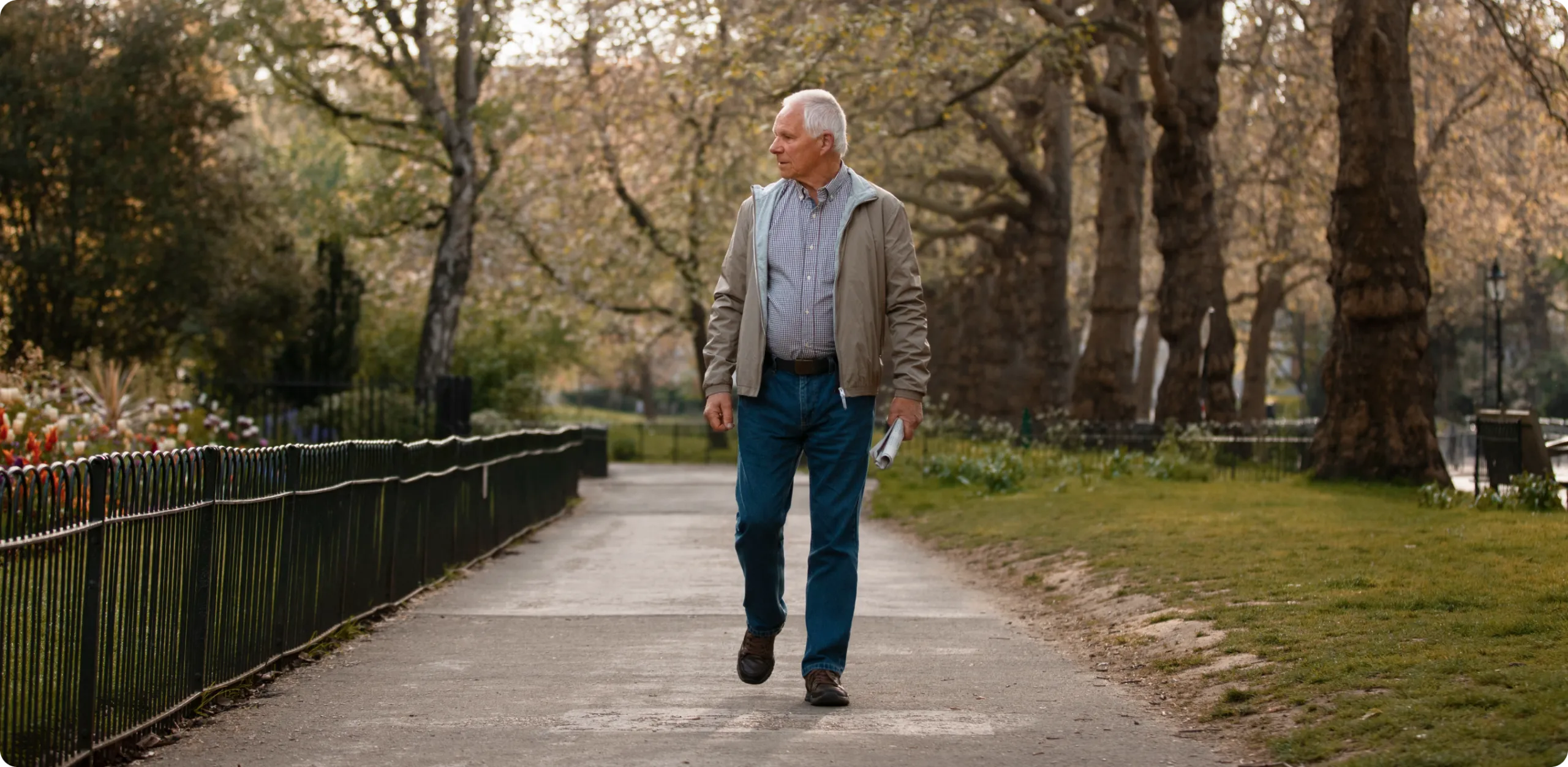 Vista frontal de un adulto mayor caminando por un sendero arbolado con expresión de búsqueda y mirada desorientada. Ilustra la importancia de la teleasistencia de Durcal para mantener la autonomía de quienes viven solos.