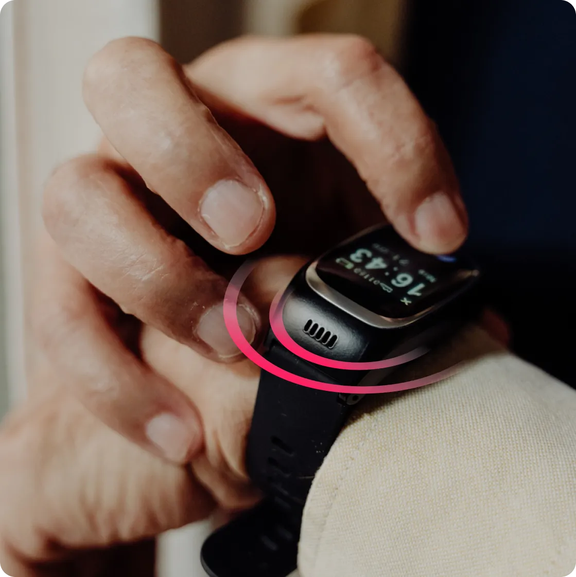 Primer plano de una mano interactuando con la pantalla de un reloj inteligente Durcal en la muñeca. El reloj, de color negro, muestra la hora (16:43) y está rodeado por un efecto gráfico de ondas circulares en tonos rojizos, sugiriendo la activación de una alerta, una notificación o la función de altavoz integrada.
