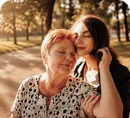 Abuela y nieta abrazadas sonriendo al aire libre