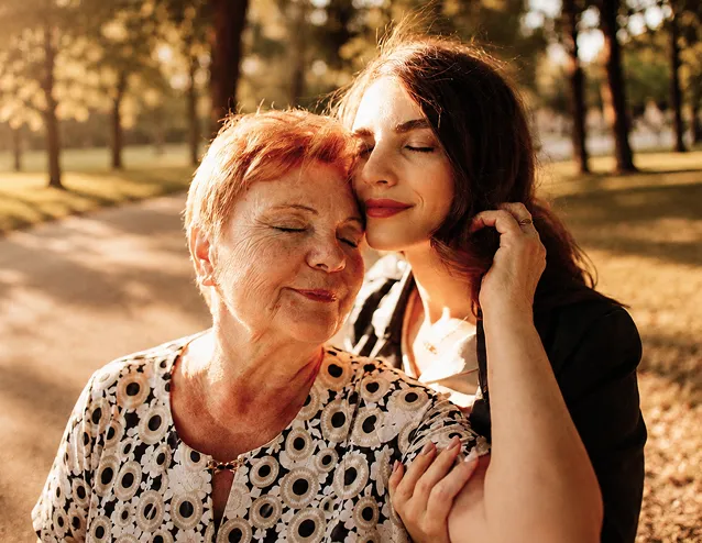 Abuela y nieta abrazadas sonriendo al aire libre con el reloj de teleasistencia Durcal