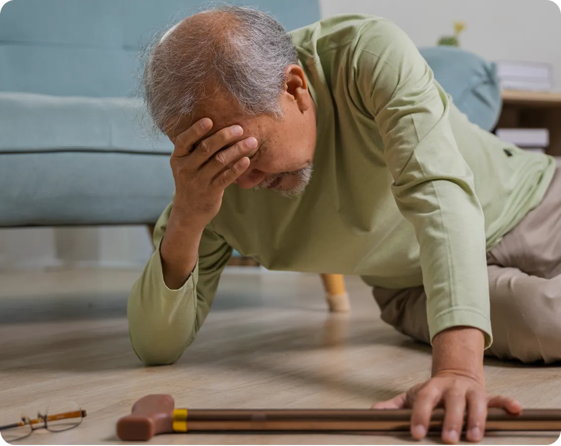 Hombre mayor que se ha caido al suelo y se levanta con dolor de cabeza 