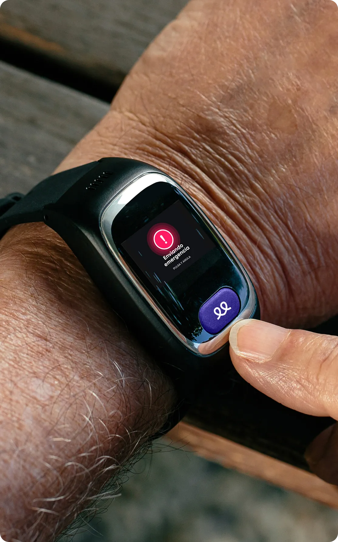 Smartwatch on elderly person's wrist showing a red alert icon on screen
