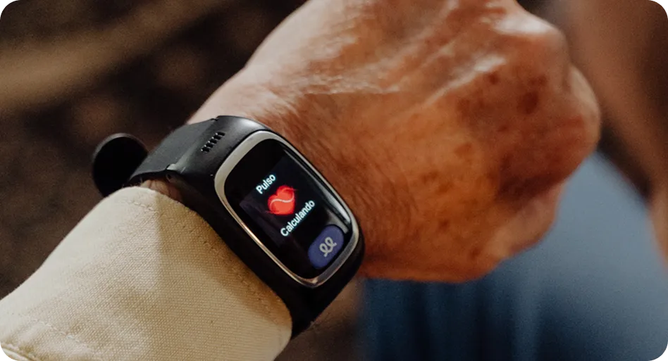 Smartwatch mostrando la medición del pulso en la muñeca de una persona mayor.